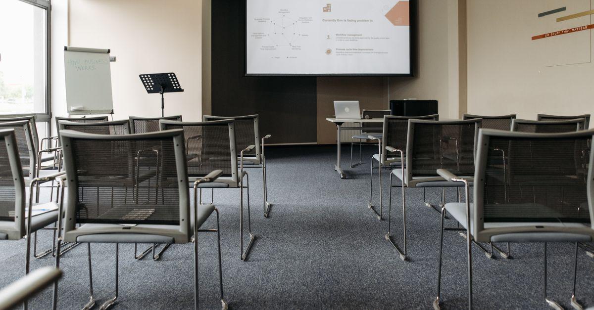 Une salle de conference vide avec des chaises un ecran de priegnck